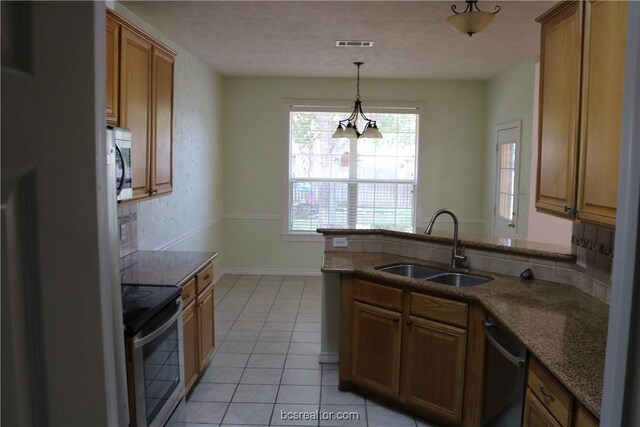 kitchen featuring sink, kitchen peninsula, pendant lighting, light tile patterned floors, and appliances with stainless steel finishes