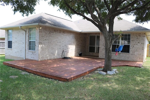 back of property with a lawn and a wooden deck