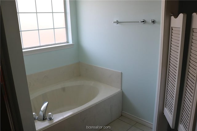 bathroom featuring tile patterned flooring and a bath