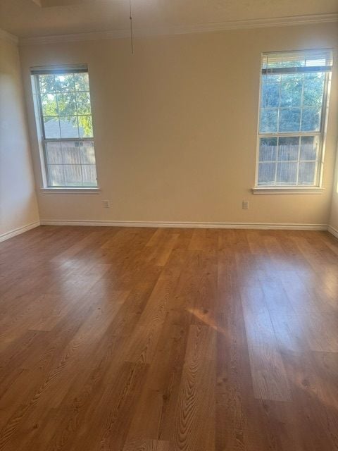 empty room featuring hardwood / wood-style flooring and ornamental molding