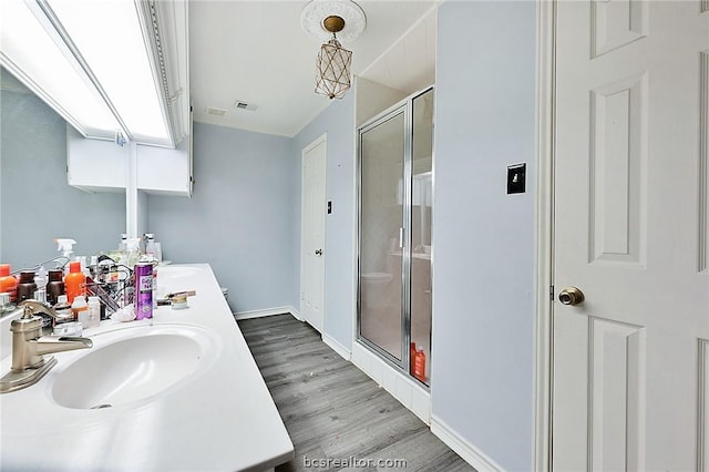 bathroom with vanity, a shower with shower door, and hardwood / wood-style flooring