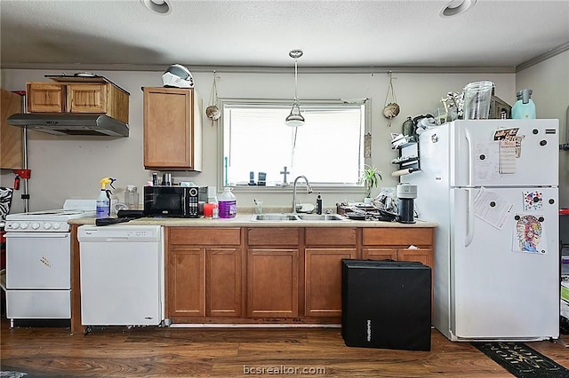 kitchen featuring white appliances, dark wood-type flooring, sink, hanging light fixtures, and a textured ceiling