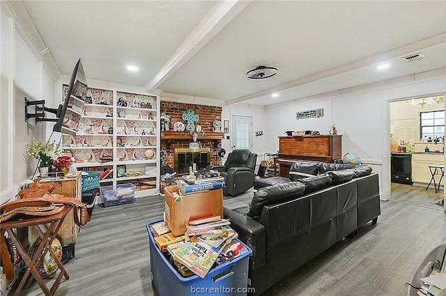 interior space featuring beam ceiling, wood-type flooring, sink, and a brick fireplace