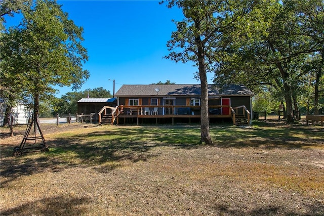 back of house with a deck and a lawn