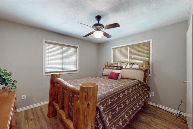 bedroom with ceiling fan, a textured ceiling, baseboards, and wood finished floors