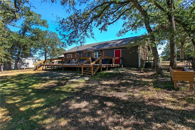 back of house featuring a deck and a lawn