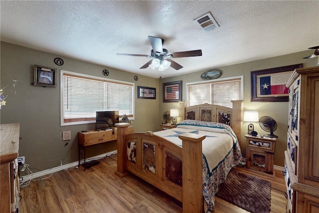 bedroom featuring light wood-style floors, multiple windows, and visible vents