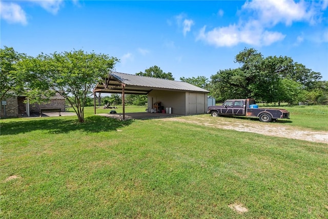 view of yard with a carport and an outbuilding