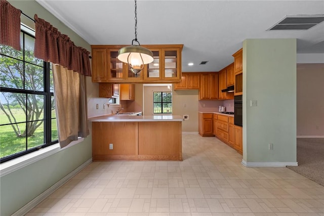 kitchen with a peninsula, baseboards, visible vents, and light countertops