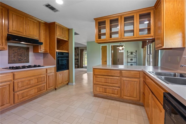 kitchen with under cabinet range hood, visible vents, a sink, black appliances, and a peninsula