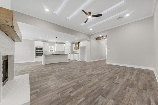 2916 Bombay Ct, Bryan, TX 77808 - unfurnished living room with a ceiling fan, light wood finished floors, a fireplace, and baseboards