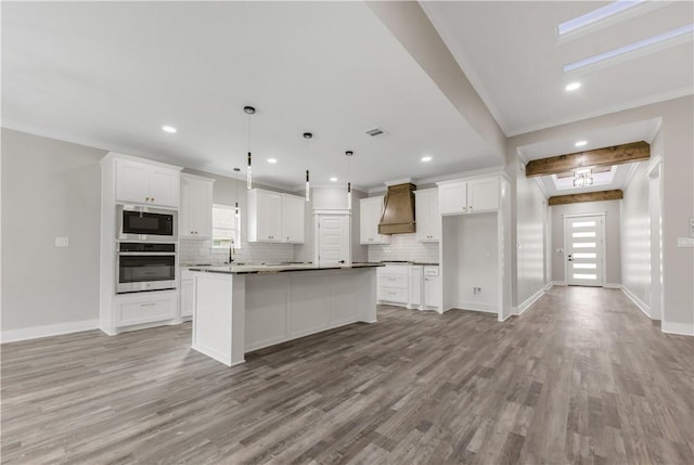 2916 Bombay Ct, Bryan, TX 77808 - kitchen with oven, premium range hood, tasteful backsplash, crown molding, and white cabinetry