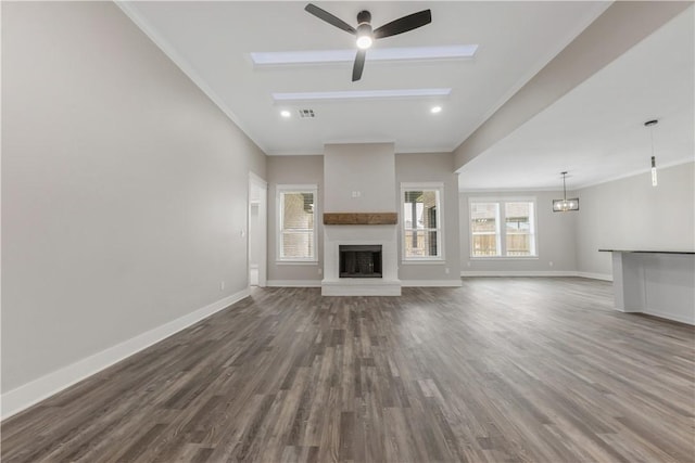 2916 Bombay Ct, Bryan, TX 77808 - unfurnished living room featuring a ceiling fan, dark wood-style flooring, crown molding, a fireplace with raised hearth, and baseboards