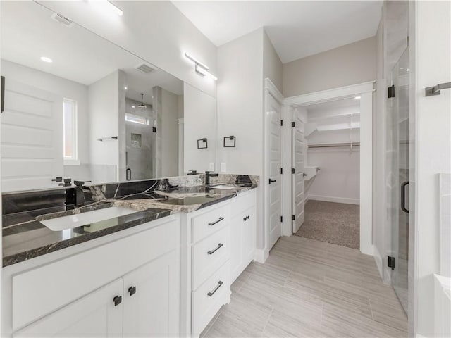 2916 Bombay Ct, Bryan, TX 77808 - full bathroom with a shower stall, a spacious closet, double vanity, and baseboards