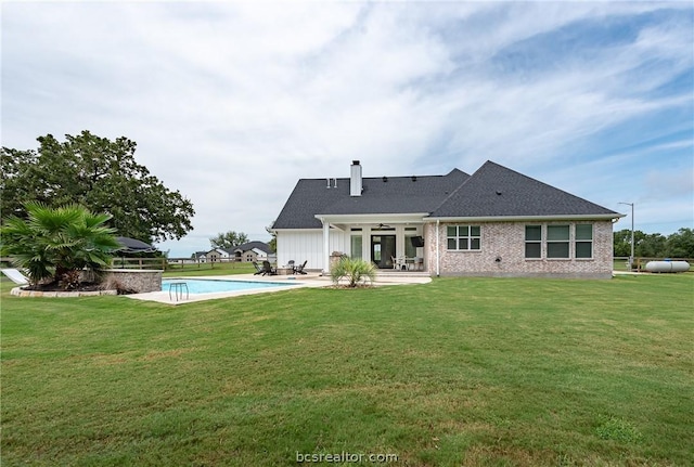 rear view of property with a patio, ceiling fan, and a lawn