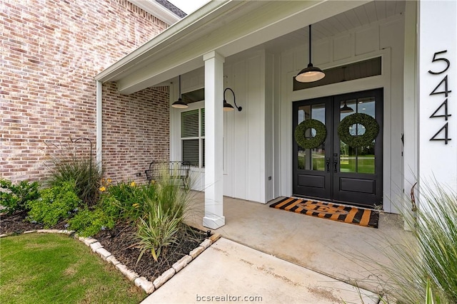 view of exterior entry featuring a porch and french doors