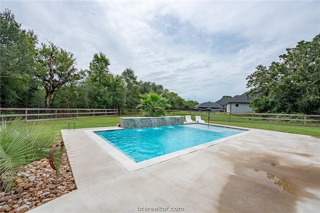 view of pool featuring pool water feature, a patio, and a lawn