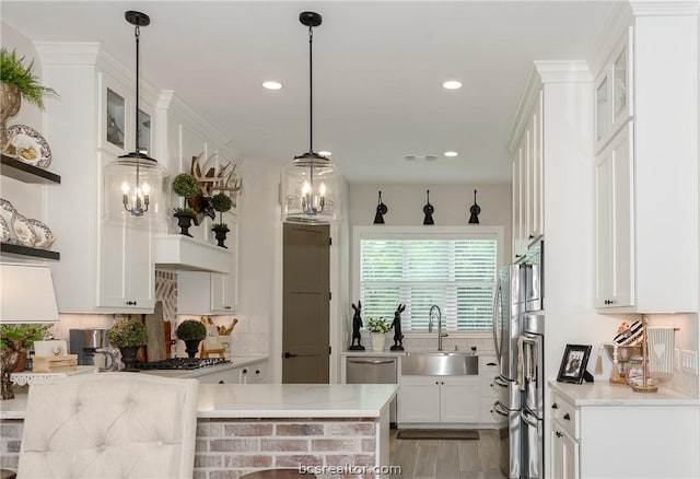 kitchen with backsplash, white cabinets, sink, light stone countertops, and kitchen peninsula