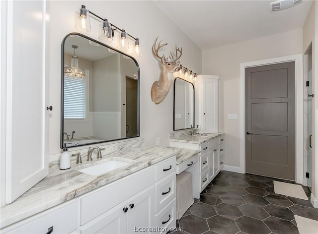 bathroom featuring tile patterned flooring, vanity, and a washtub