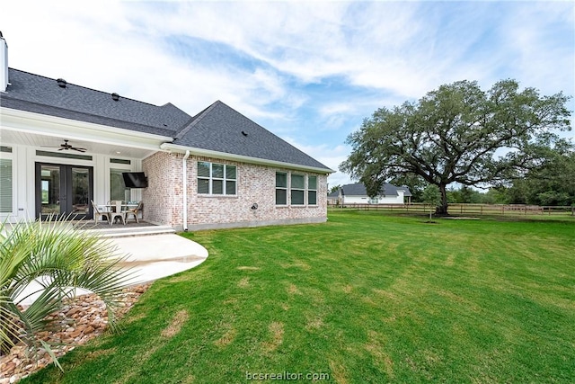 back of property with ceiling fan, a yard, a patio, and french doors