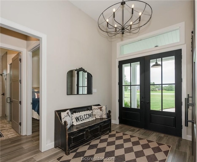 entryway featuring dark hardwood / wood-style flooring, french doors, and a chandelier