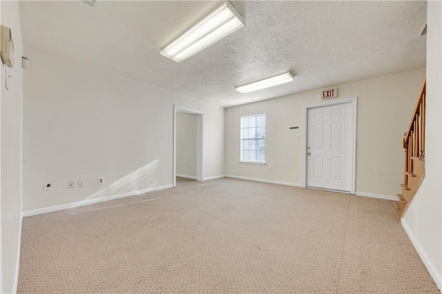 empty room featuring light colored carpet and a textured ceiling