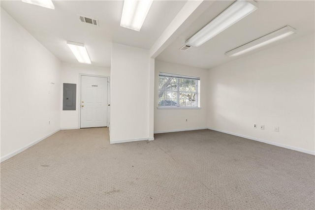 spare room with light carpet and electric panel