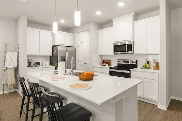 1326 Prairie Dr Unit 113, Bryan, TX 77803 - kitchen featuring appliances with stainless steel finishes, baseboards, a breakfast bar area, backsplash, and recessed lighting