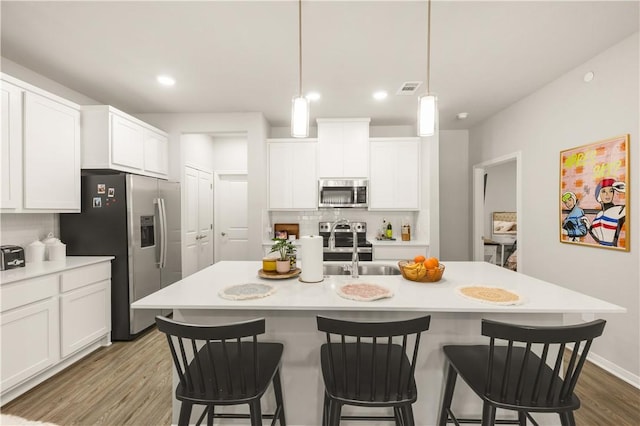 1326 Prairie Dr Unit 113, Bryan, TX 77803 - kitchen with appliances with stainless steel finishes, wood finished floors, light countertops, white cabinetry, and recessed lighting