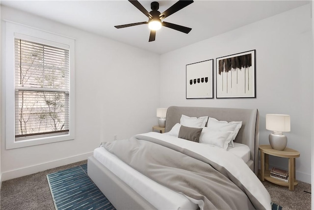 bedroom with baseboards, dark carpet, and ceiling fan