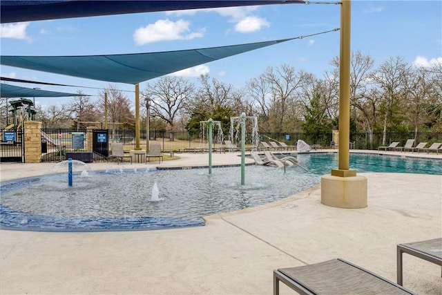 community pool featuring a patio area, fence, and playground community