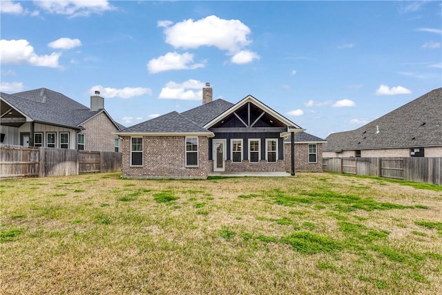 back of property featuring brick siding, a lawn, and a fenced backyard