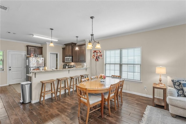 1611 Park Pl, College Station, TX 77840 - dining area with dark wood-style flooring and ornamental molding