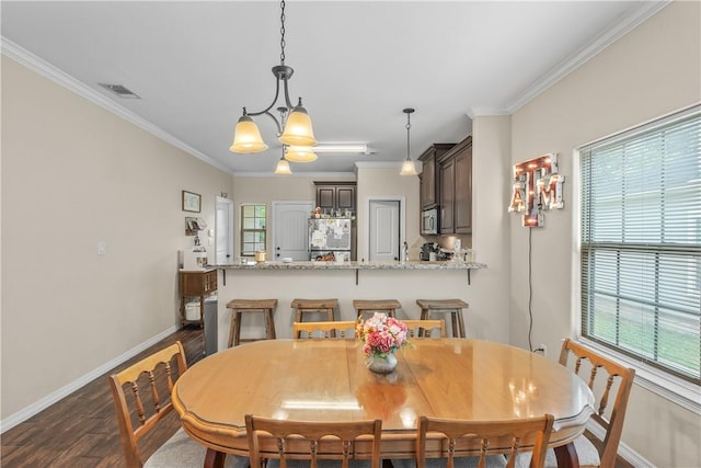 1611 Park Pl, College Station, TX 77840 - dining space with dark wood finished floors, ornamental molding, plenty of natural light, and a chandelier