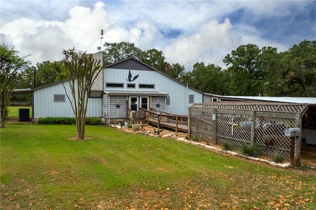 rear view of property featuring a deck and a yard