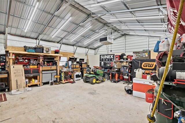 garage featuring a garage door opener, a workshop area, and metal wall