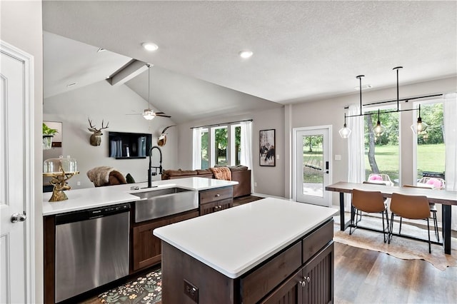 kitchen with open floor plan, light countertops, dishwasher, and a sink