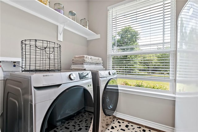 washroom featuring baseboards, independent washer and dryer, laundry area, and a healthy amount of sunlight