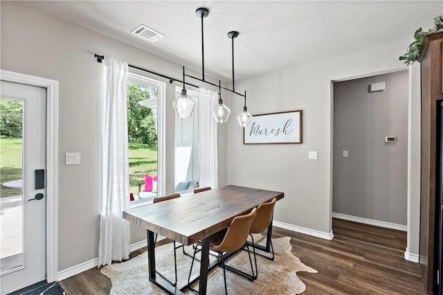 dining room with visible vents, baseboards, and dark wood-type flooring