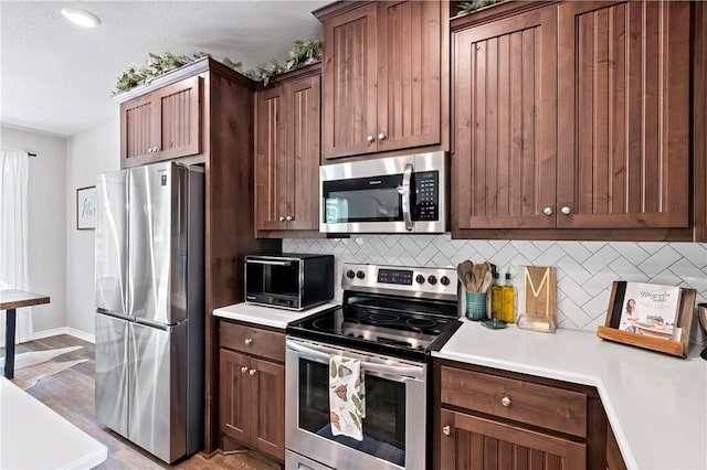 kitchen featuring appliances with stainless steel finishes, decorative backsplash, and light countertops