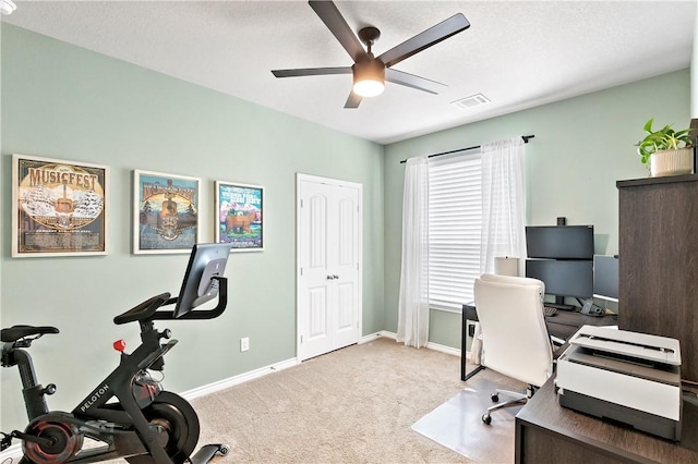 carpeted office space featuring a ceiling fan, visible vents, and baseboards