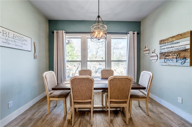 dining space featuring hardwood / wood-style flooring and a chandelier