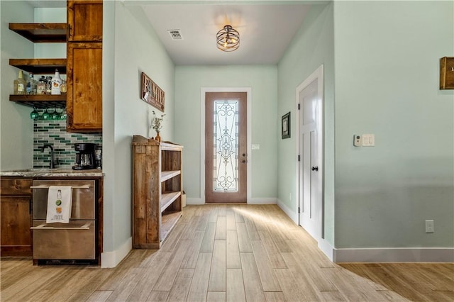 foyer featuring light hardwood / wood-style flooring and bar area