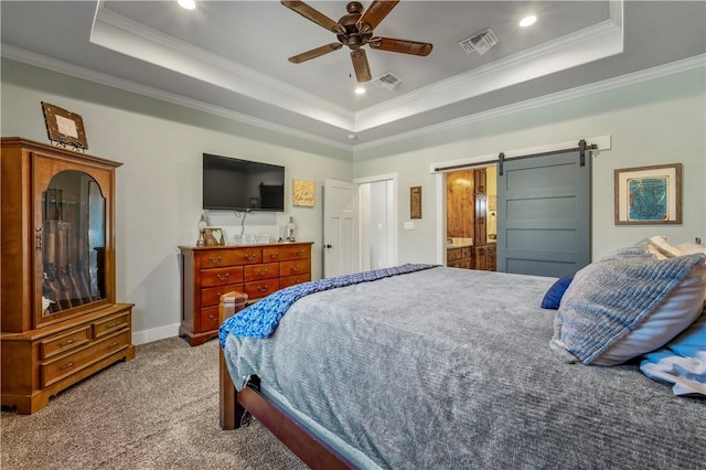 carpeted bedroom featuring ceiling fan, a barn door, and a raised ceiling