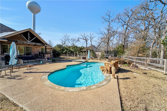 view of swimming pool with a trampoline, a hot tub, and a patio