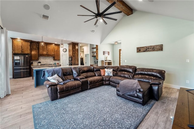 living room featuring beamed ceiling, ceiling fan, high vaulted ceiling, and light wood-type flooring