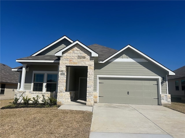 craftsman-style home featuring a garage, stone siding, board and batten siding, and driveway