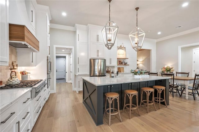 kitchen featuring recessed lighting, light wood-style flooring, appliances with stainless steel finishes, and a breakfast bar