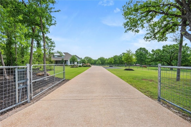 view of community featuring a gate, a yard, and fence