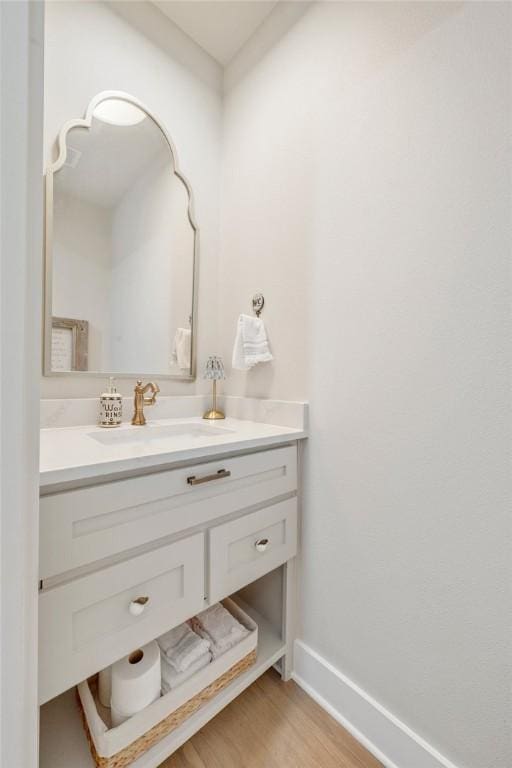 bathroom with wood finished floors, baseboards, and vanity